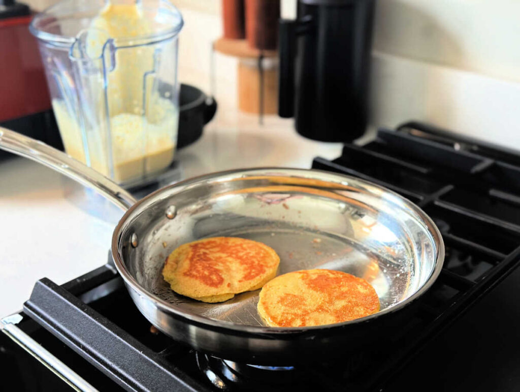 golden brown pancakes on the stove top in a griddle